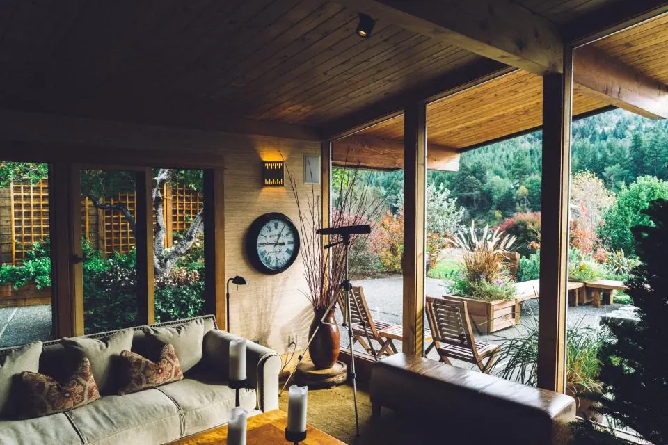 Salón con sofá y muebles de madera junto a un ventanal