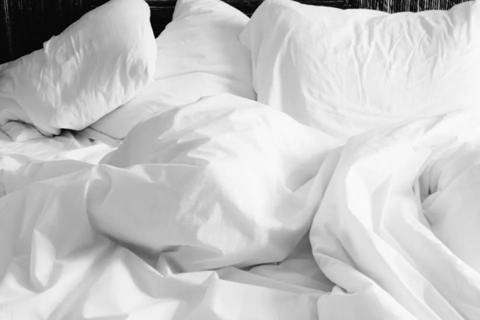 Sábanas blancas sobre una cama