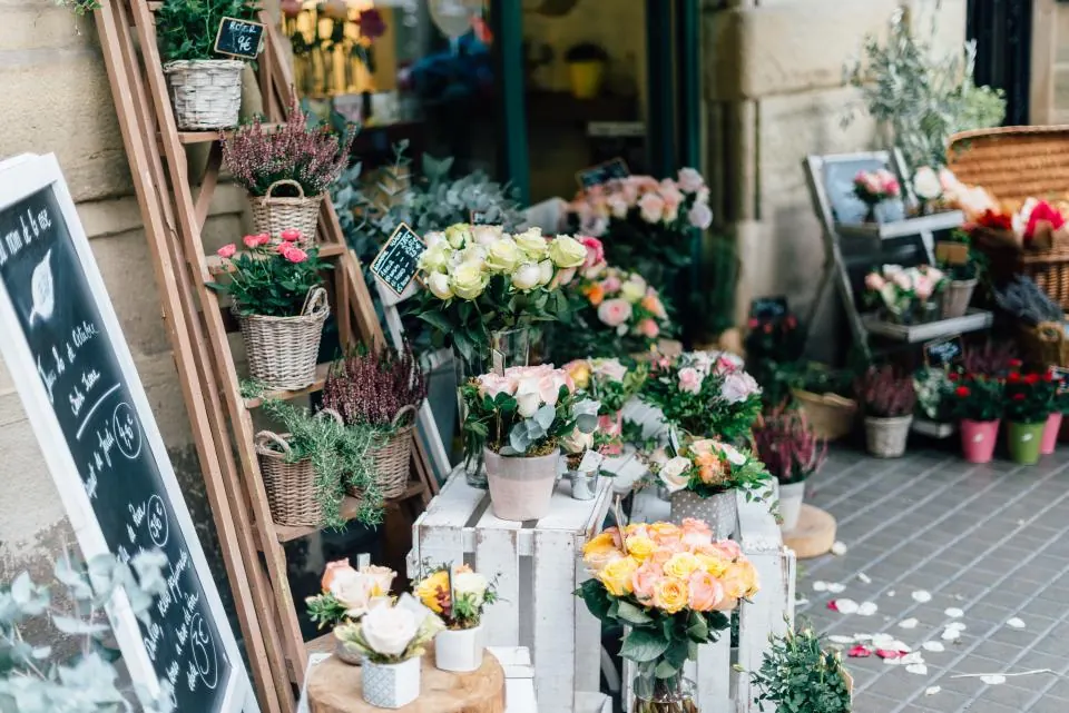 Entrada de una floristería llena de cubos con flores de colores